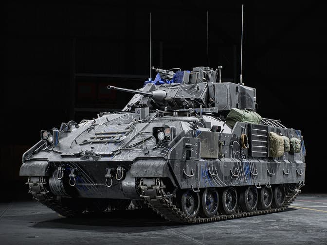Armoured tracked military vehicle detailed with gear and antennas.