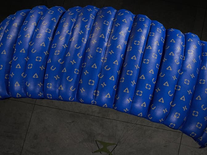 Blue parachute canopy patterned with small symbols.