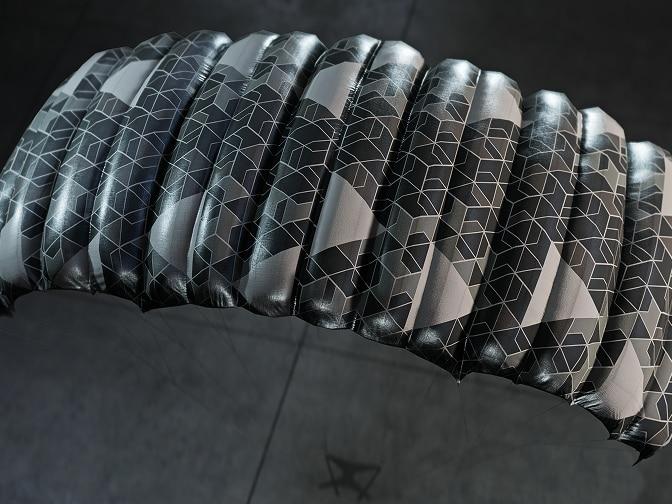 A parachute with a dark and light gray geometric pattern.