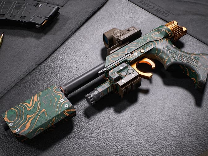 Compact pistol with green-and-orange patterned skin and mounted attachments.