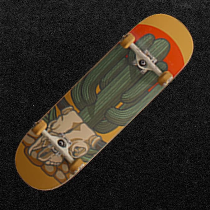 Skateboard deck with desert cactus, skull, and orange sunset graphic